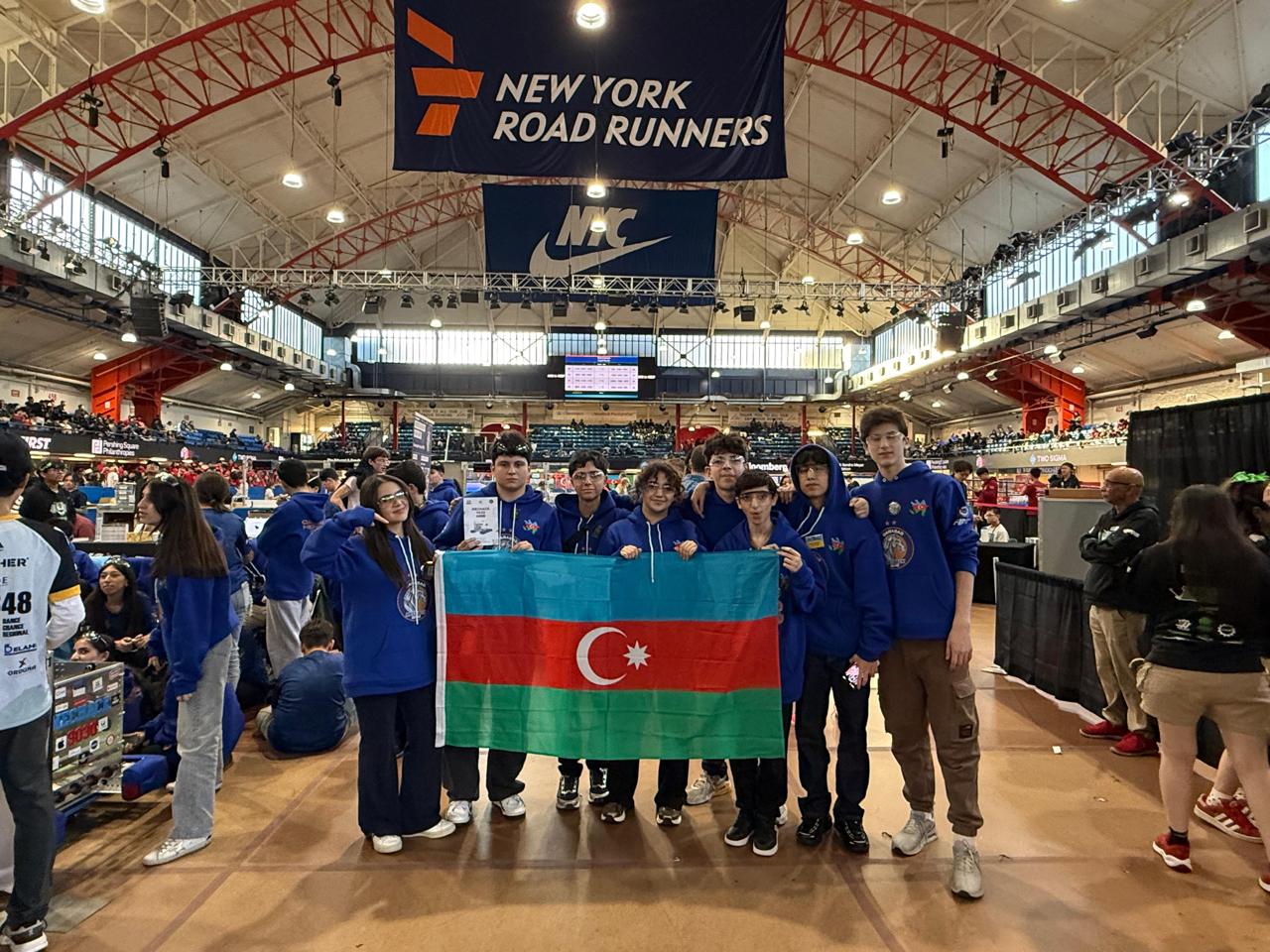 Qarabağ MecHack 9030 members holding the Azerbaijan flag at the FRC arena