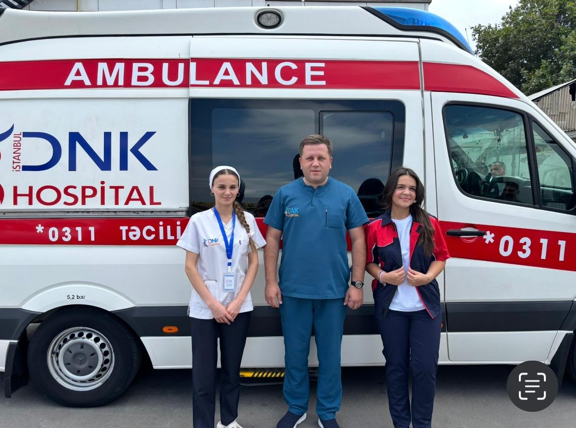 Farah with a DNK İstanbul Hospital doctor and paramedic in front of an ambulance